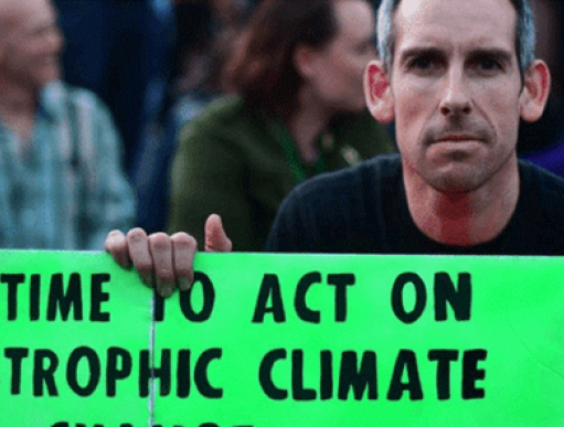 Etienne Scott holding a Climate Action poster