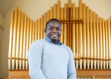 Man wearing jumper at front of church with organ