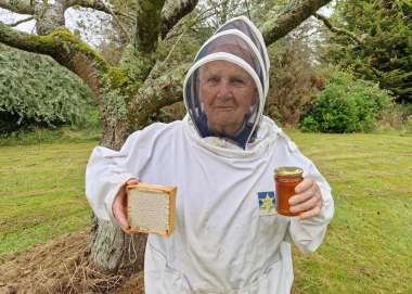 Beekeper holding honey